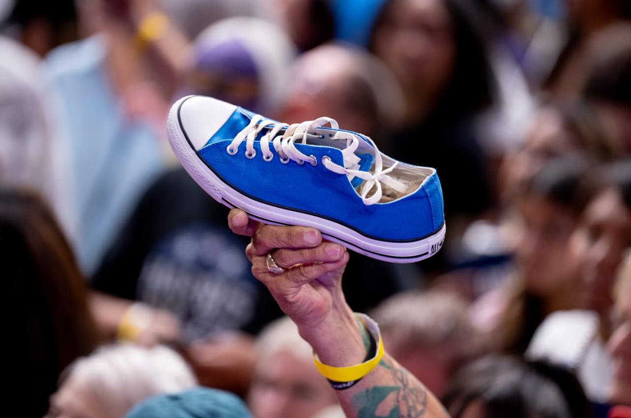 A man holds up a Converse Chuck Taylor – Kamala Harris' favorite footwear – during the vice president's campaign rally on Aug. 9, 2024, in Glendale, Ariz. <a href="https://www.gettyimages.com/detail/news-photo/man-holds-up-a-converse-chuck-taylor-shoe-as-democratic-news-photo/2165587885?adppopup=true" rel="nofollow noopener" target="_blank" data-ylk="slk:Andrew Harnik/Getty Images;elm:context_link;itc:0;sec:content-canvas" class="link ">Andrew Harnik/Getty Images</a>