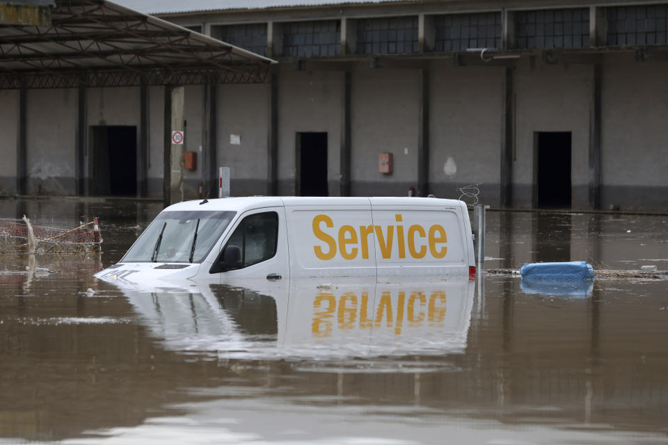 A vehicle is half submerged in floodwater, outside a business after a rainstorm, in Larissa, Thessaly region, central Greece, Thursday, Sept. 7, 2023. Greece's fire department says more than 800 people have been rescued over the past two days from floodwaters, after severe rainstorms turned streets into raging torrents, hurling cars into the sea and washing away roads. (AP Photo/Vaggelis Kousioras)