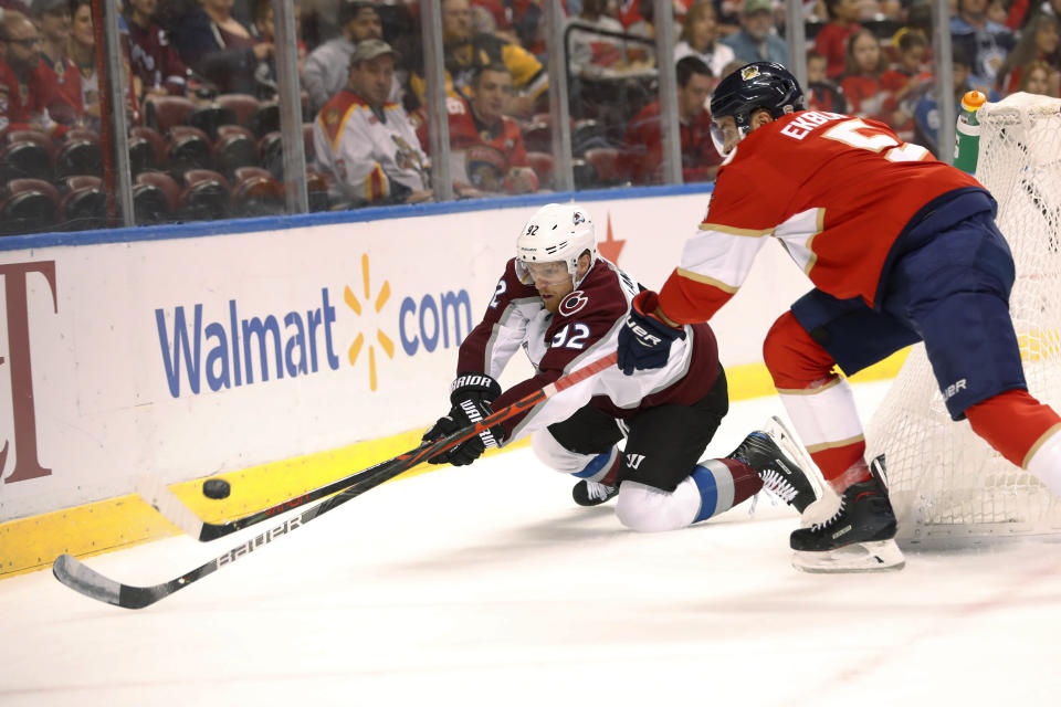 Colorado Avalanche left wing Gabriel Landeskog (92) and Florida Panthers defenseman Aaron Ekblad (5) vie for the puck during the first period of an NHL hockey game Friday, Oct. 18, 2019 in Sunrise, Fla. (AP Photo/Wilfredo Lee)