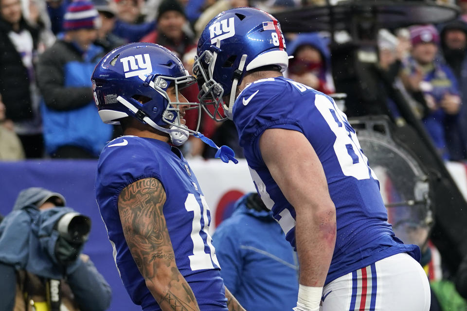 New York Giants wide receiver Isaiah Hodgins (18) celebrates with tight end Daniel Bellinger (82) after scoring a touchdown against the Philadelphia Eagles during the second quarter of an NFL football game, Sunday, Dec. 11, 2022, in East Rutherford, N.J. (AP Photo/Bryan Woolston)