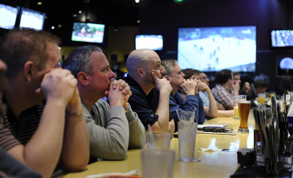 Patrons of a restaurant watch as the United States Men's Olympic Hockey team loses to Canada at the Sochi Olympics, Friday, Feb. 21, 2014 in College Park, Md. (AP Photo/Susan Walsh)