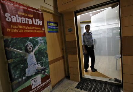 A private security guard stands on the door of a Sahara India Life Insurance office in Kolkata, India, August 25, 2015. REUTERS/Rupak De Chowdhuri