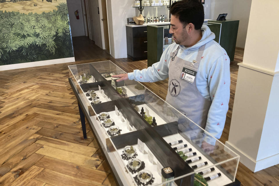 Marijuana dispensary manager LeRoy Roybal of Santa Fe, N.M., prepares on Tuesday, March 29, 2022, for the opening of New Mexico's regulated market for recreational cannabis at a Minerva Canna store. At midnight on Friday, April 1, 2022, it becomes legal for anyone 21 and older to purchase and possess up to 2 ounces (57 grams) of marijuana for personal use -- enough to roll about 60 joints or cigarettes. New Mexico is among 18 states that have broadly legalized marijuana for personal use. (AP Photo/Morgan Lee)