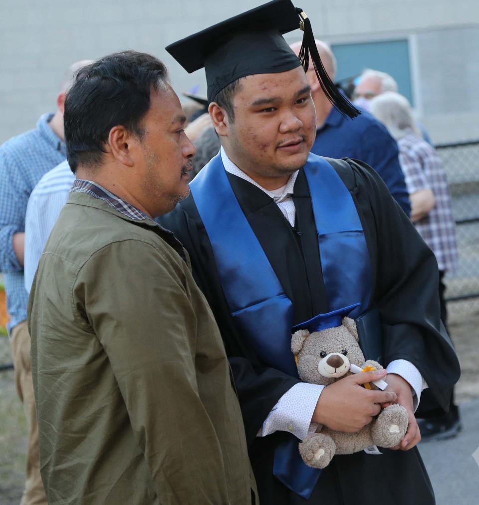 Tyler Sar holds a graduation bear gift after he earns his degree in criminal justice from York County Community College May 13, 2022.