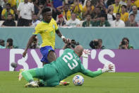 Brazil's Vinicius Junior, left, challenges for the ball with Serbia's goalkeeper Vanja Milinkovic-Savic during the World Cup group G soccer match between Brazil and Serbia, at the Lusail Stadium in Lusail, Qatar, Thursday, Nov. 24, 2022. (AP Photo/Natacha Pisarenko)