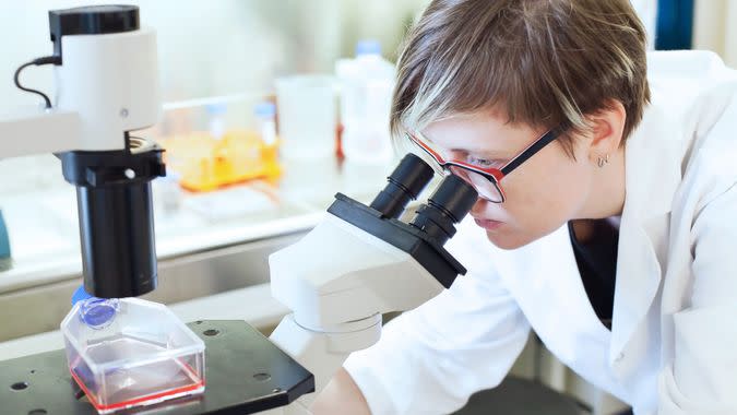 female scientist in laboratory using microscope