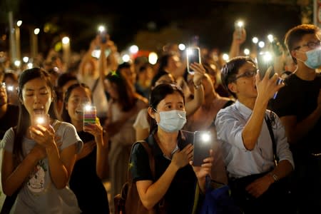 People hold up their mobile phone during the Mid-Autumn Festival, in Sha Tin