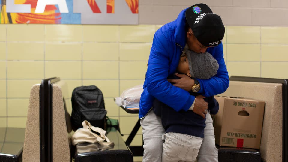 Franklin Jose Rivero hugs his stepson Jean Luis Hernandez at Robert F. Wagner Middle School in New York. - Laura Oliverio/CNN