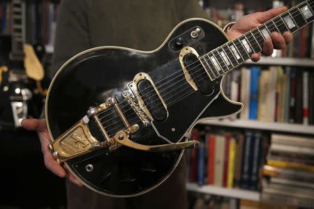 Guernsey's Auctions President Arlan Ettinger holds the Les Paul guitar known as "Black Beauty", which will go up for auction next month, in New York January 29, 2015. REUTERS/Mike Segar