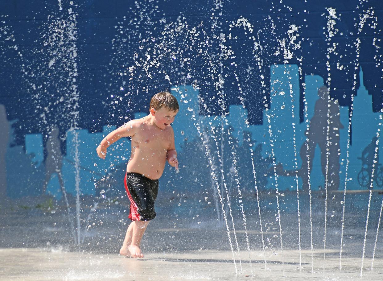 Sebastian Stevens, 4 years old, sprints through the water at Johns Park on Wednesday morning.