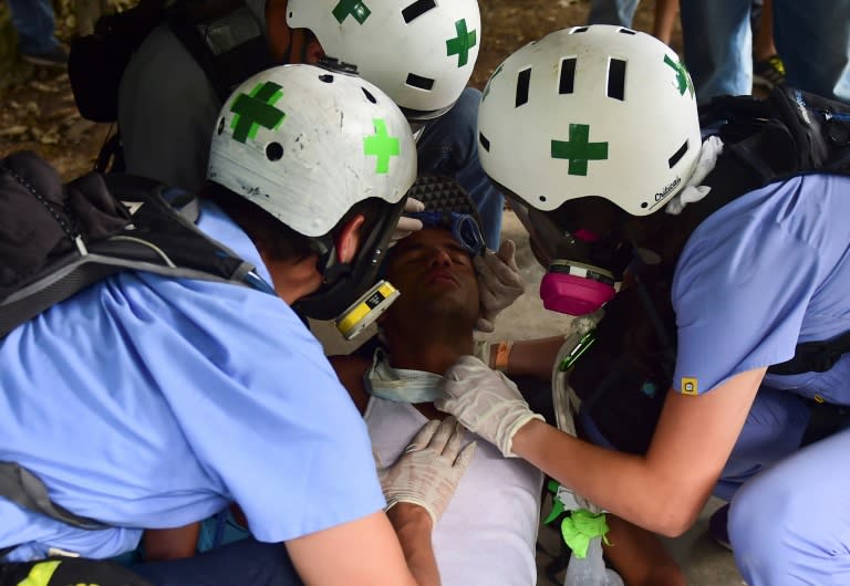 An injured opposition activist is assisted after clashes with riot police at the Central University of Venezuela on May 4, 2017