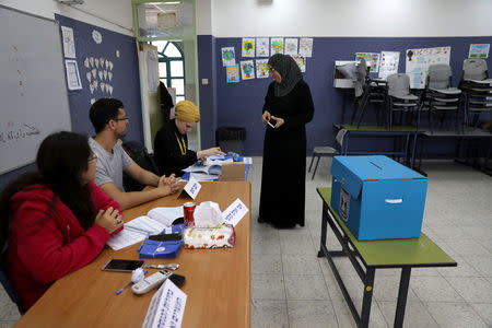 An Israeli-Arab woman prepares to casts her ballot as Israelis vote in a parliamentary election, at a polling station in Umm al-Fahm, Israel April 9, 2019. REUTERS/Ammar Awad