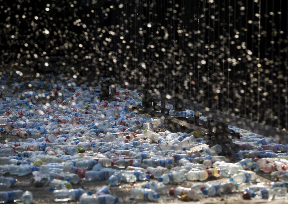 Water splash from a bottle thrown by a demonstrator at the main entrance gate of Japanese Embassy during a protest in Beijing Sunday, Sept. 16, 2012. Security personnel outnumbered the crowds of Chinese protesting against Japan outside its embassy on Sunday, a day after demonstrations over islands that both nations claim spread across China and turned violent. (AP Photo/Andy Wong)