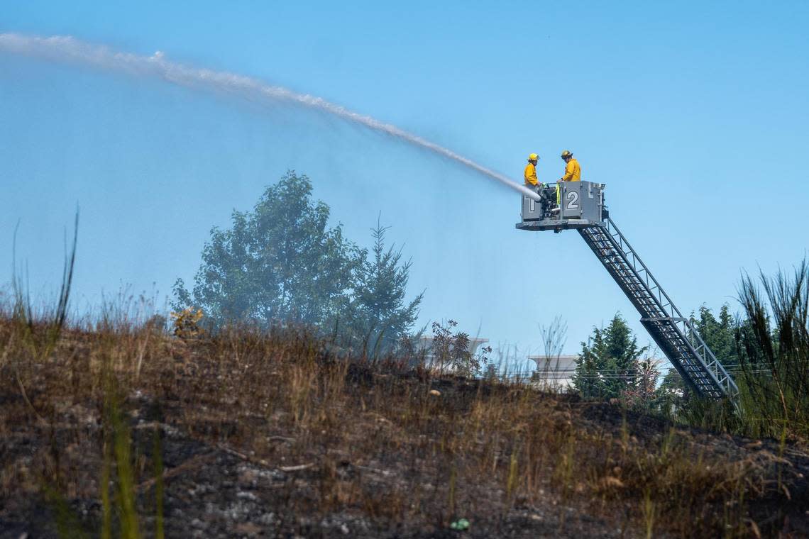 Firefighters work to extinguish a brush fire that ignited near I-5 and S. Hosmer Street on Monday Aug. 8, 2022