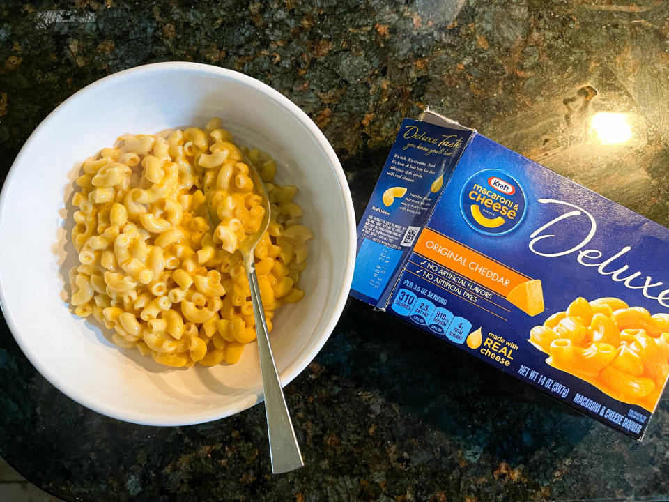 Kraft deluxe cooked in a bowl, next to its original packaging