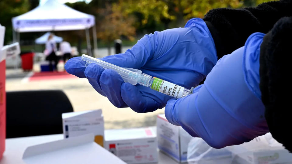 Isabel Vining, a medical assistant at AFC Urgent Care in Marlborough, holds a syringe with the flu vaccine during a drive-through flu clinic in October at Hudson High School.