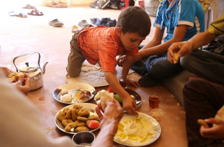 A Syrian family, who has been evacuated from the town of Daraya, share a breakfast upon their arrival at a government reception centre on August 27, 2016 in the government-held town of Hrajela, outside Damascus