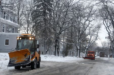 A sidewalk plow and a street plow work to clear a neighborhood in Bangor, Maine, U.S. December 30, 2016. REUTERS/Ashley Conti