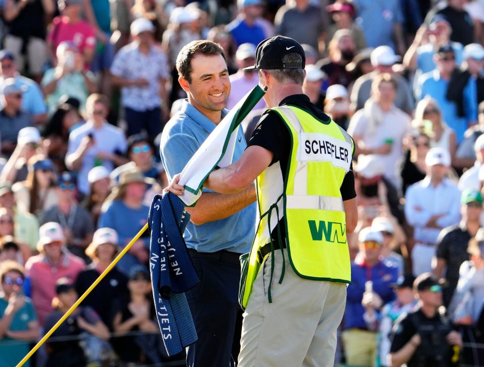 Scottie Scheffler exchanges congratulations with his caddie Ted Scott after winning the Phoenix Open this past Sunday. It was the second year in a row that Scheffler has won the tournament.