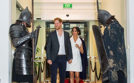 Britain's Prince Harry and Meghan, the Duke and Duchess of Sussex, are greeted by actors in costume as hey arrive for a visit to Courtenay Creative, in Wellington, New Zealand October 29, 2018. Dominic Lipinski/Pool via Reuters