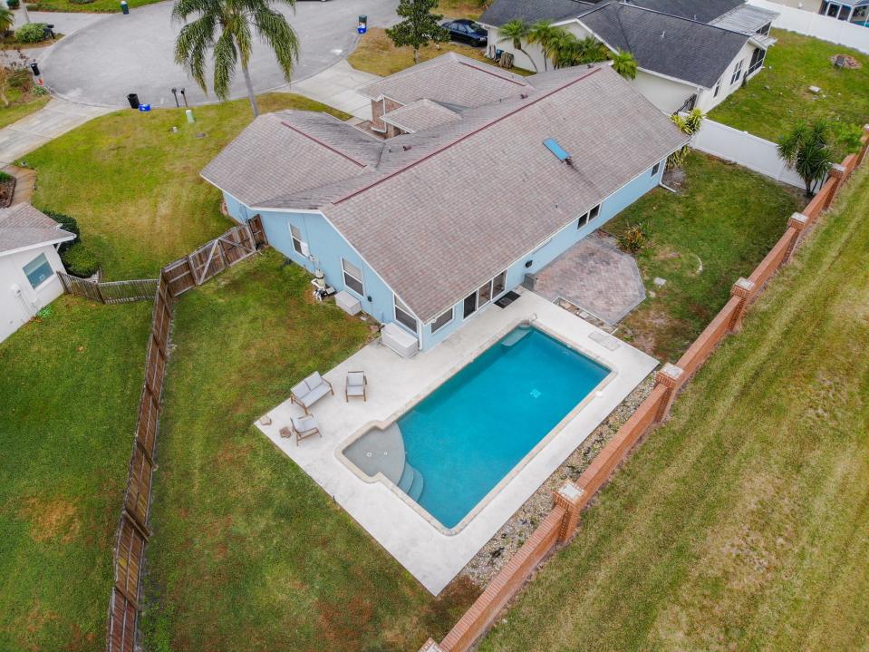 Sliders lead out to the large pie-shaped fenced yard, where the new owners can spend their days enjoying the inviting inground pool.