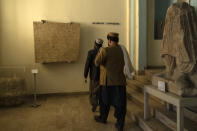Visitors walk in front of a second century AC limestone in Bactrian Language on a Greek script in the National Museum of Afghanistan, in Kabul, Monday, Dec. 6, 2021. The National Museum of Afghanistan is open once again -- and the Taliban, whose members once smashed their way through the facility, destroying irreplaceable pieces of Afghanistan's national heritage, now appear to be among its most enthusiastic visitors. (AP Photo/Petros Giannakouris)