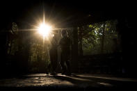 Ana-Maria Simionescu, left, a dance instructor of the Swing Steps Bucharest club, dances with Marian Ganciu at sunset, in Bucharest, Romania, Sunday, Oct. 3, 2021. Members of the club gathered for an outdoor dance session in the Kisselef park, as the sharp rise of new COVID-19 infections led to restrictions of some indoor group activities. (AP Photo/Andreea Alexandru)