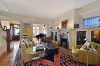 <p>The home’s large living room has wood floors, etched glass windows, beautiful moldings and a fireplace. (Zillow) </p>