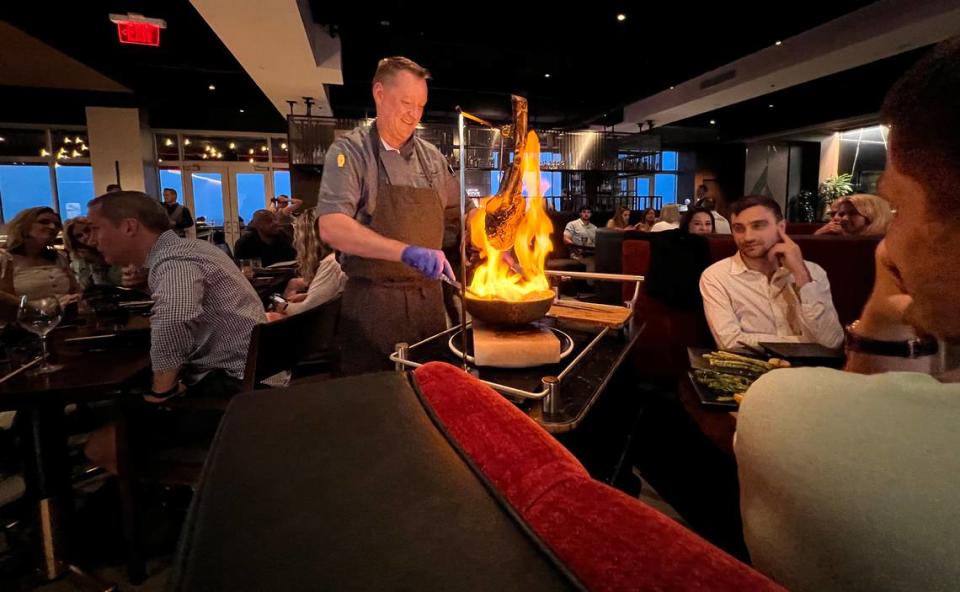 Executive chef Dustin Hildebrandt cooks the Wagyu Supreme Tomahawk tableside at Hestia Rooftop.