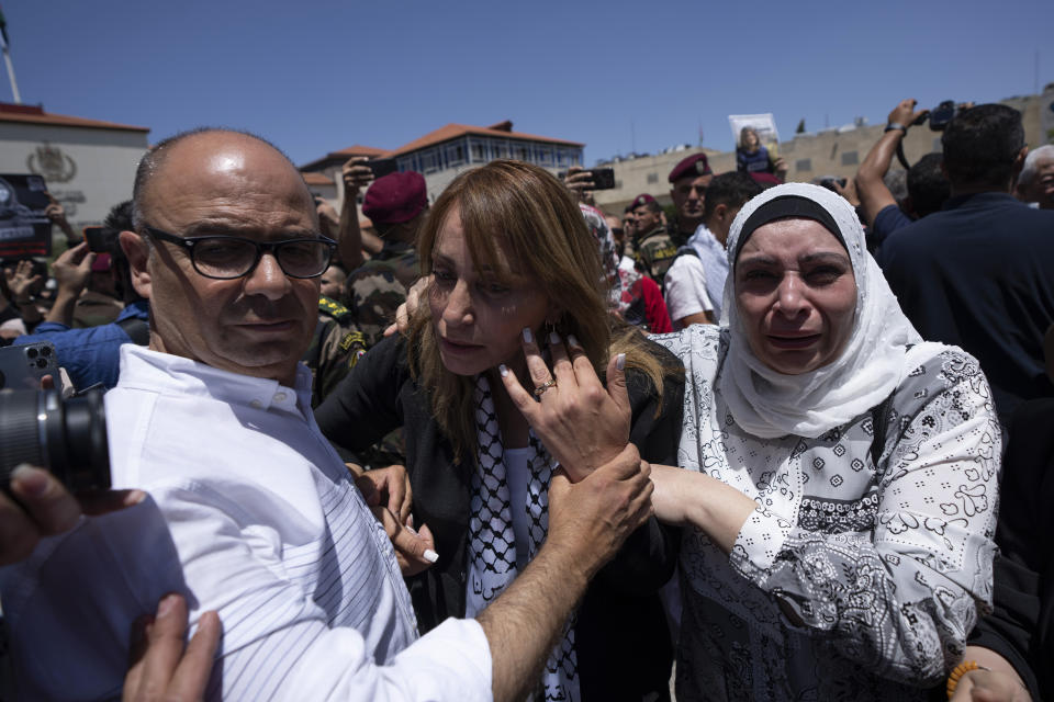 Palestinian friends and colleagues of slain Al Jazeera journalist Shireen Abu Akleh, who was shot dead Wednesday during an Israeli military raid in the West Bank city of Jenin, cry and comfort each other during an official ceremony at the Palestinian Authority headquarters in Ramallah, Thursday, May 12, 2022. Thousands gathered to mourn Abu Akleh in the occupied West Bank city of Ramallah on Thursday, as the head of the Palestinian Authority blamed Israel for her death and rejected Israeli calls for a joint investigation. (AP Photo/Nasser Nasser)