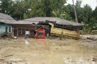 A truck is submerged in mud after flash floods swept through Radda Village, as several people were killed and dozens remain missing in North Luwu in Sulawesi