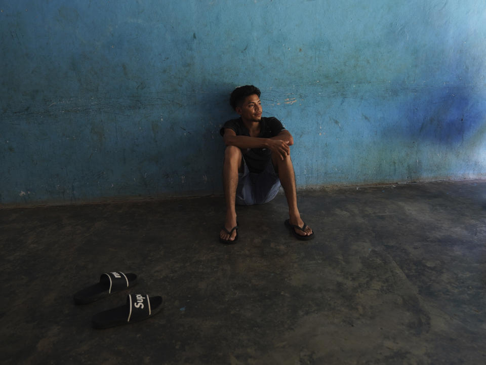 A migrant sits on the floor of a local's home where he is paying to stay while waiting on the Mexican immigration office to accept his application for legal migration documents and give a him "safe passage" permit in Tapachula, Chiapas state, Mexico, Monday, Oct. 3, 2022. A local taxi driver rents out space to migrants looking for lodging, for 100 pesos, or about $5 dollars a night. (AP Photo/Marco Ugarte)