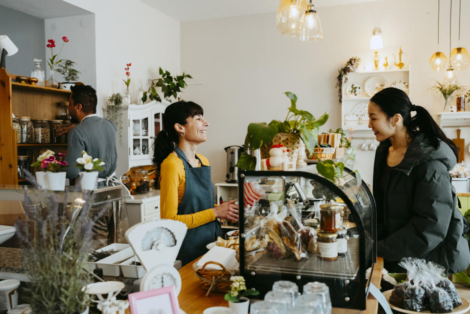 woman working with a customer at the front of a bakery