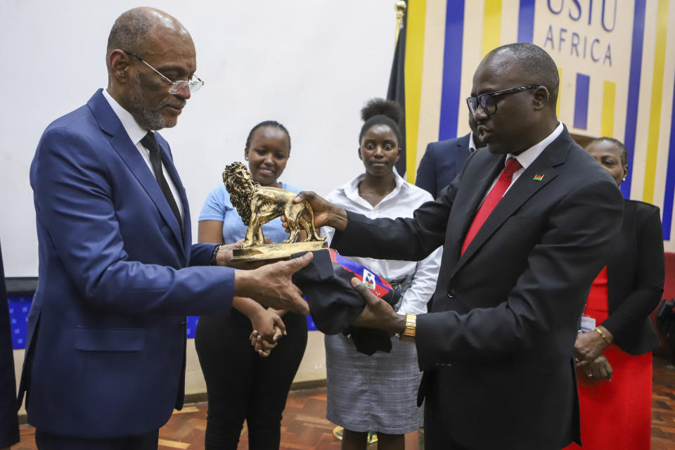 Haiti Prime Minister Ariel Henry, left, is presented a gift by Korir SingOei, Kenya's Secretary for Foreign Affairs, at the United States International University (USIU) in Nairobi, Kenya, Friday March. 1, 2024. Haitian Prime Minister Ariel Henry said Friday elections in his country need to be held as soon as possible in order to bring stability to the troubled Caribbean nation facing gang violence that threatens to overran government. Henry is in Kenya trying to salvage the deployment of a foreign armed force to Haiti to help combat gangs. (AP Photo/Andrew Kasuku)