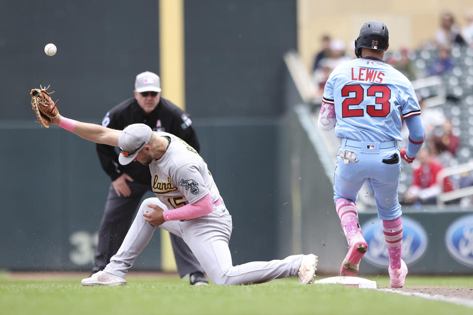 Minnesota Twins' Royce Lewis (23) makes it safely to first base against Oakland Athletics first baseman Seth Brown (15) after hitting a ground ball to shortstop Elvis Andrus during the fourth inning of a baseball game Sunday, May 8, 2022, in Minneapolis. (AP Photo/Stacy Bengs)
