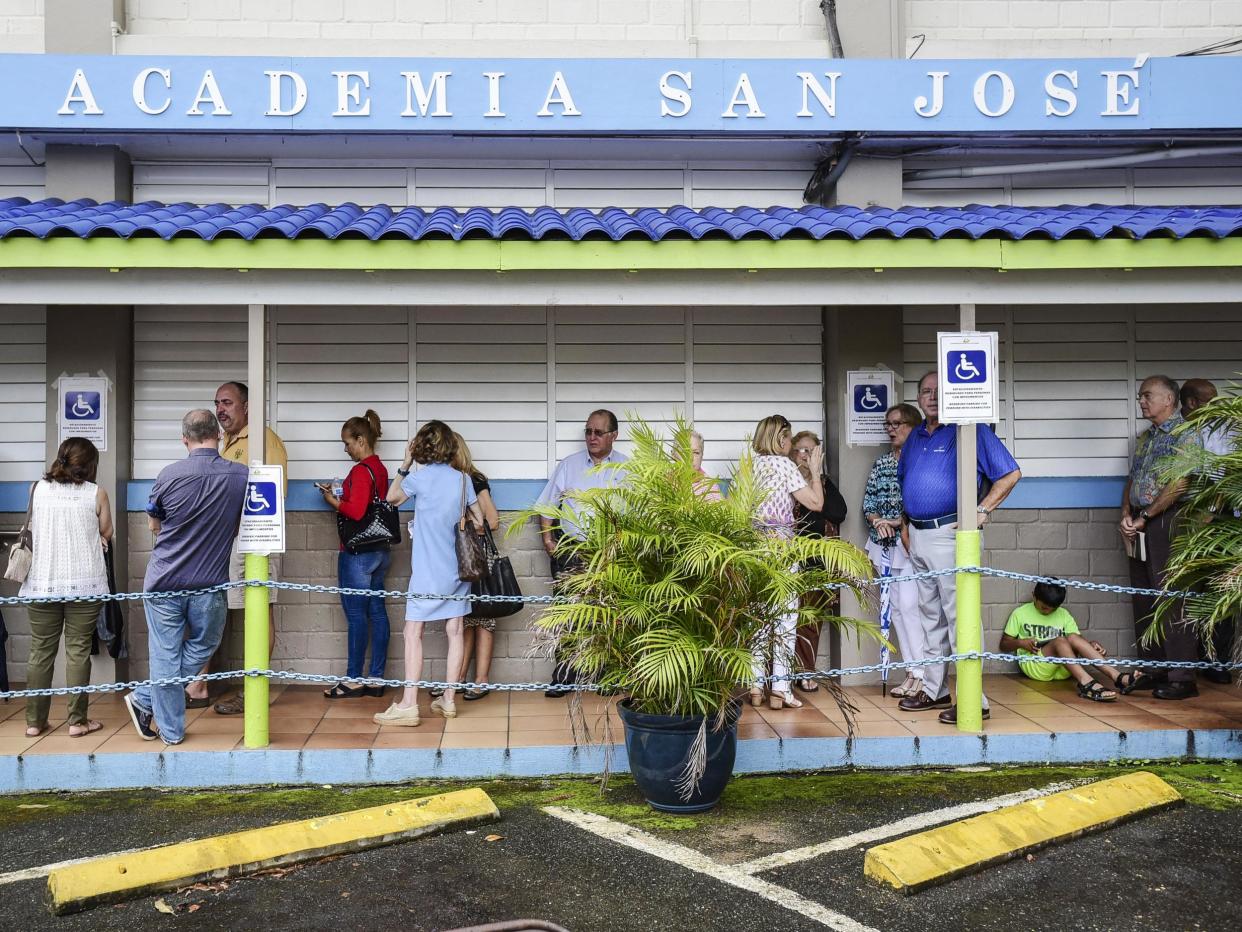 Puerto Rican citizens wait in line to vote during the fifth referendum in San Juan, Puerto Rico, on Sunday 11 June: Associated Press