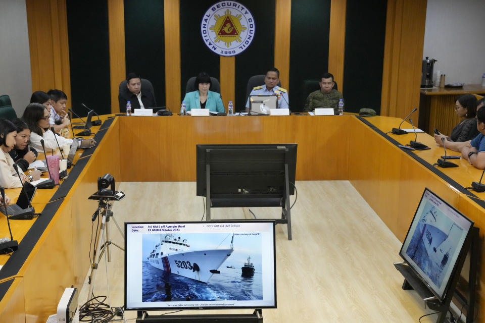 Philippine Coast Guard spokesperson, Commodore Jay Tarriela, second from left, shows reporters a video of an incident involving a Chinese coast guard ship with bow number 5203 and a Philippine military-run supply boat during a press conference In Quezon City, Philippines on Monday, Oct. 23, 2023. A Chinese coast guard ship and an accompanying vessel rammed a Philippine coast guard ship and a military-run supply boat Sunday off a contested shoal, Philippine officials said, in an encounter that heightened fears of an armed conflict in the disputed South China Sea. (AP Photo/Aaron Favila)