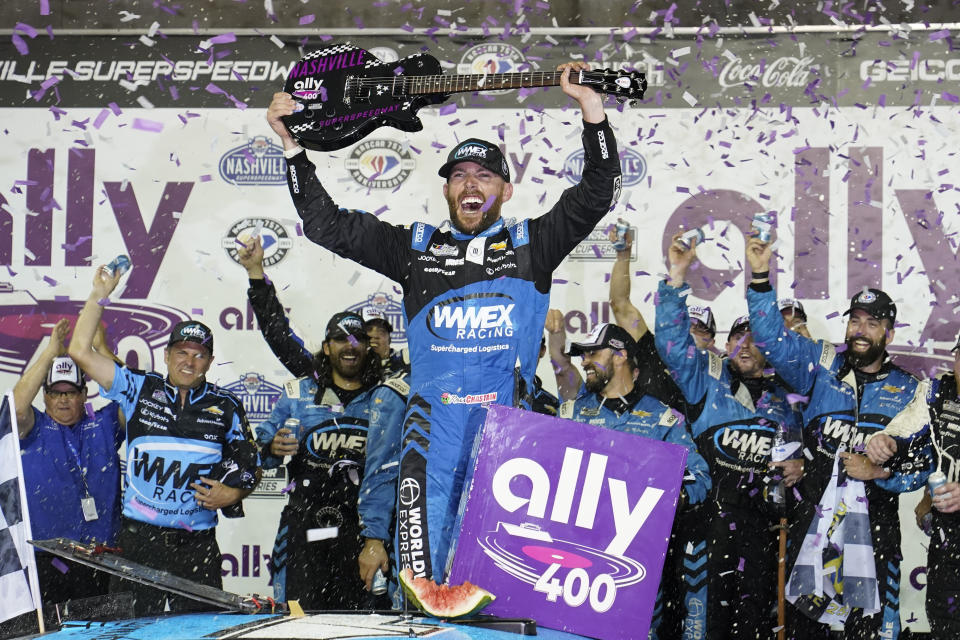 Ross Chastain holds a guitar presented to him after winning a NASCAR Cup Series auto race, Sunday, June 25, 2023, in Lebanon, Tenn. (AP Photo/George Walker IV)