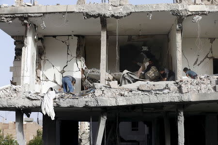 People salvage furniture from the rubble of a house destroyed by an air strike in Sanaa. REUTERS/Khaled Abdullah