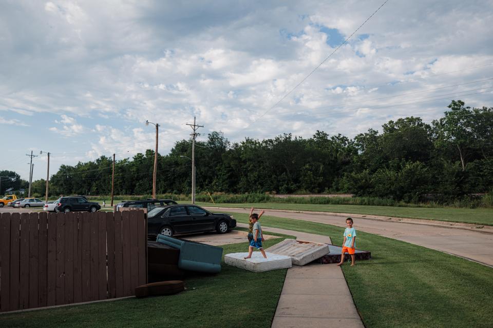 Children play on the discarded mattresses and furniture piled near the dumpsters at the Brookhaven complex.