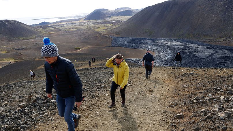 People walk to view the eruptions of the Fagradalsfjall volcano in Iceland on August 3, 2022.