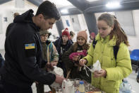 A rescue worker makes tea for children at the heating tent "Point of Invincibly" in Bucha, Ukraine, Monday, Nov. 28, 2022. (AP Photo/Evgeniy Maloletka)
