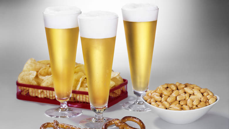 Pilsner glasses next to snacks