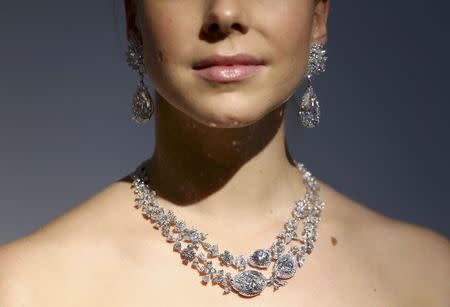 An assistant poses with Miroir de l'Amour, a pair of flawless diamond pear-shaped earrings and the diamond necklace Le Jardin d'Isabelle, during a sale preview at Christie's auction house in London, Britain October 20, 2016. REUTERS/Neil Hall