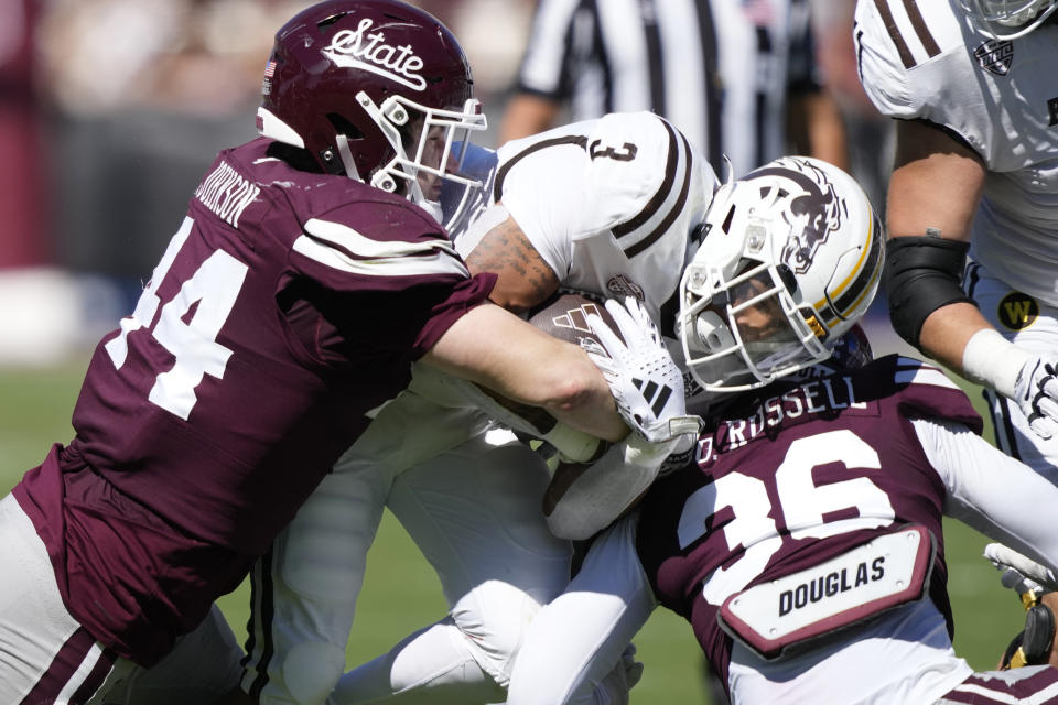 Western Michigan running back CJ Hester (3) is tackled by Mississippi State linebacker Jett Johnson (44) and defensive lineman Donterry Russell (36) during second half of an NCAA college football game, Saturday, Oct. 7, 2023, in Starkville, Miss. (AP Photo/Rogelio V. Solis)