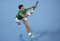 Serbia's Novak Djokovic makes a forehand return to Germany's Jan-Lennard Struff during their first round singles match at the Australian Open tennis championship in Melbourne, Australia, Monday, Jan. 20, 2020. (AP Photo/Andy Brownbill)