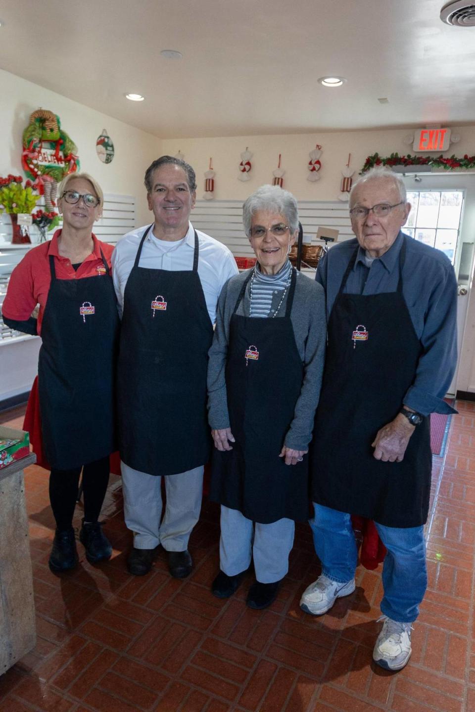 Lisa and Rob Sharp stand with Rob’s parents, Becky and Bob Sharp, on the 50th anniversary of Sharp’s Candies store on Regency Road.