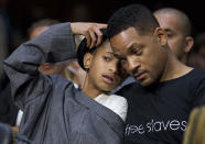 Actor Will Smith, and his daughter Willow Camille Reign Smith, accompanying Jada Pinkett Smith, not in picture, testifying in a Senate Foreign Relations Committee hearing about human trafficking, communicate in whisper, on Capitol Hill in Washington Tuesday, July 17, 2012. (AP Photo/Manuel Balce Ceneta)