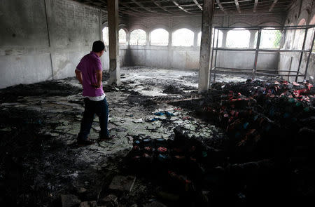 A man stands inside a burned house where, according to local media, six people died, during a protest against Nicaragua's President Daniel Ortega's in Managua, Nicaragua June 16, 2018. REUTERS/Oswaldo Rivas