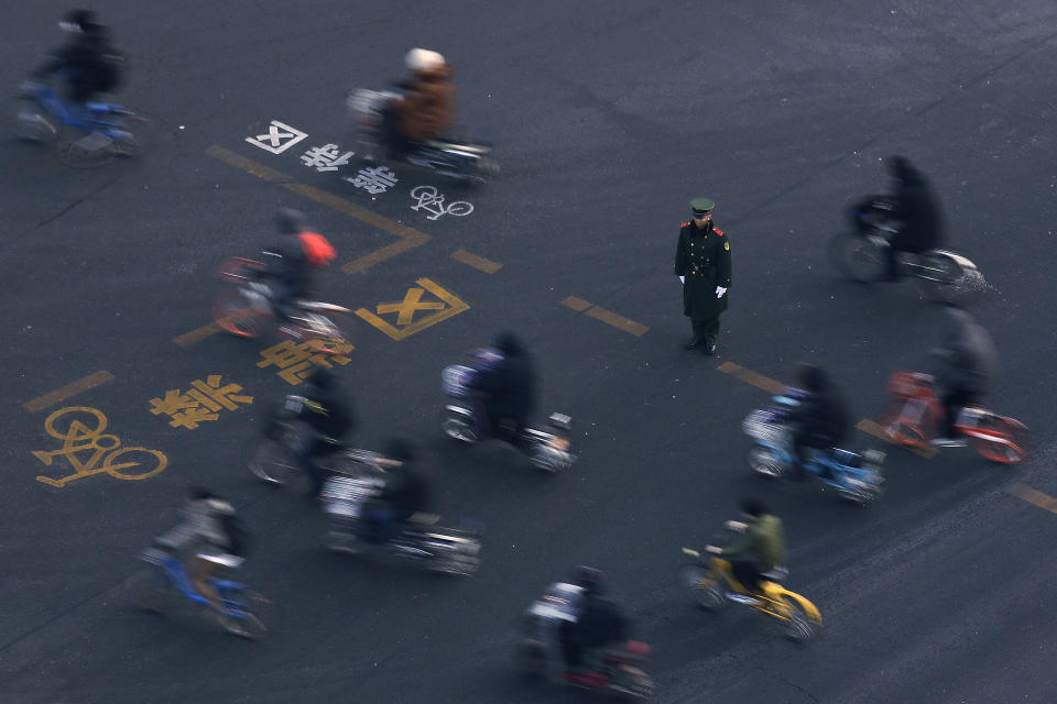 People on bicycle move past a Chinese paramilitary policeman standing guard on the road to maintain safety for visiting North Korean leader Kim Jong Un to traveling past the Chang'an Avenue in Beijing, Wednesday, Jan. 9, 2019. North Korean state media reported Tuesday that Kim is making a four-day trip to China in what's likely an effort by him to coordinate with his only major ally ahead of a summit with U.S. President Donald Trump that could happen early this year. (AP Photo/Andy Wong)